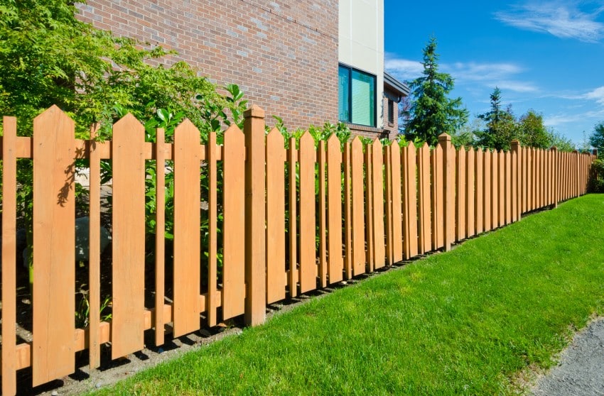 Country style long wooden cedar yellow fence.