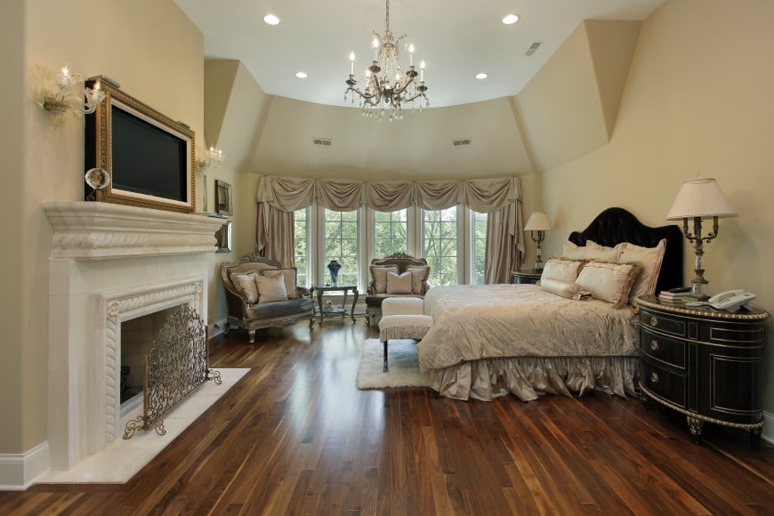 this bedroom is set in neutral beige and features a white marble fireplace