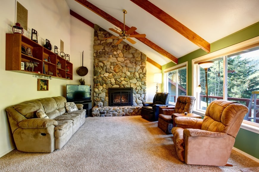 living room with fireplace and stone wall