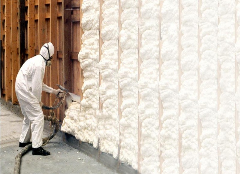 worker applying spray foam insulation